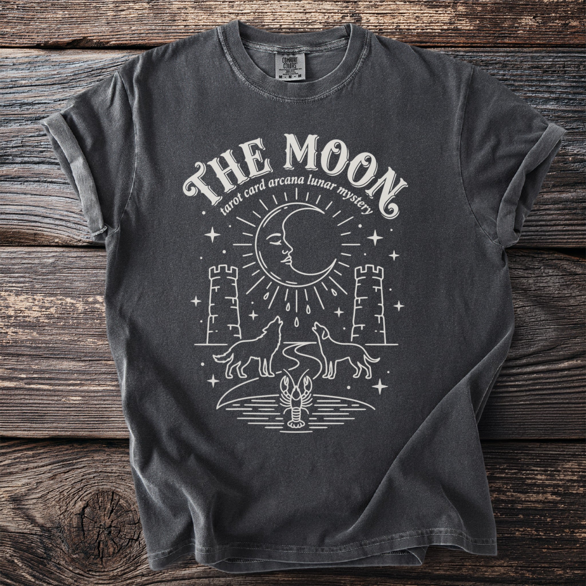 Dark gray t-shirt with "The Moon tarot card arcana lunar mystery" graphic.