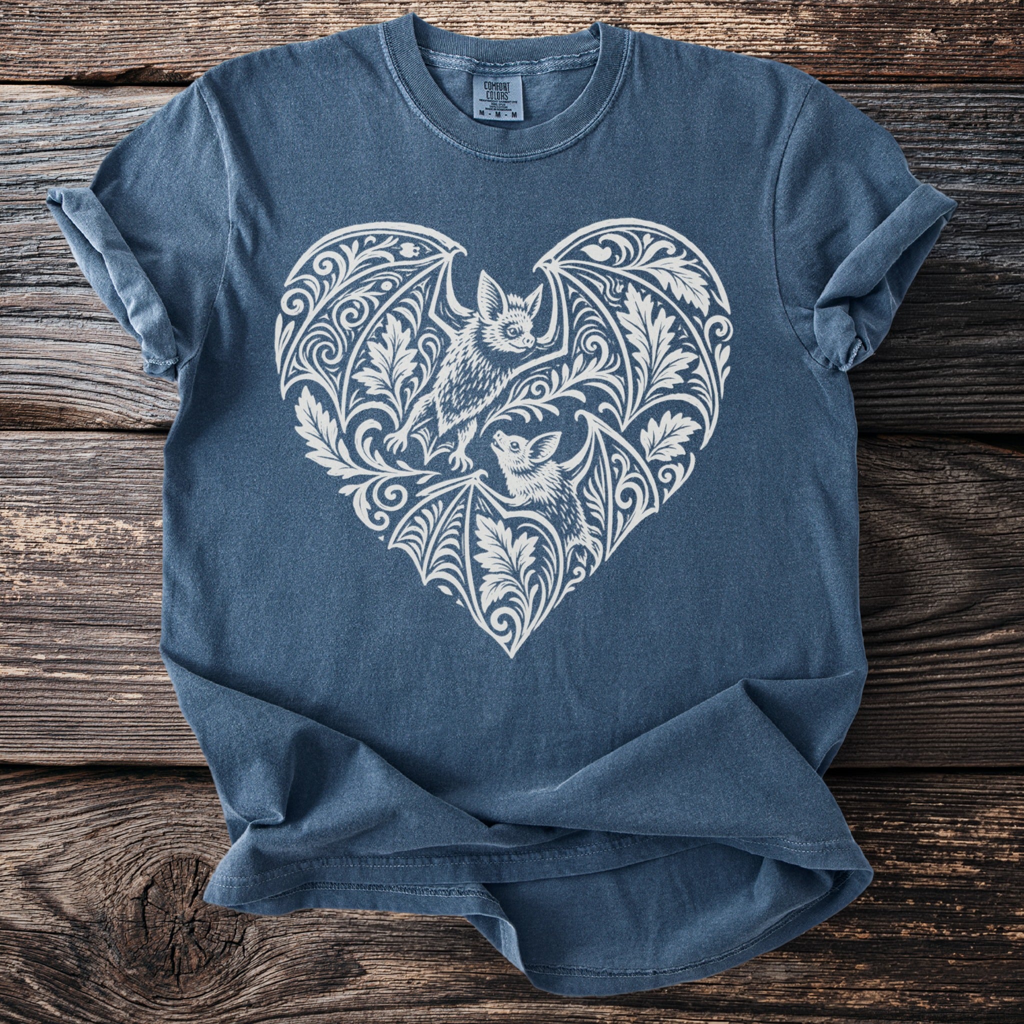 Blue t-shirt with white heart-shaped bat and floral design.