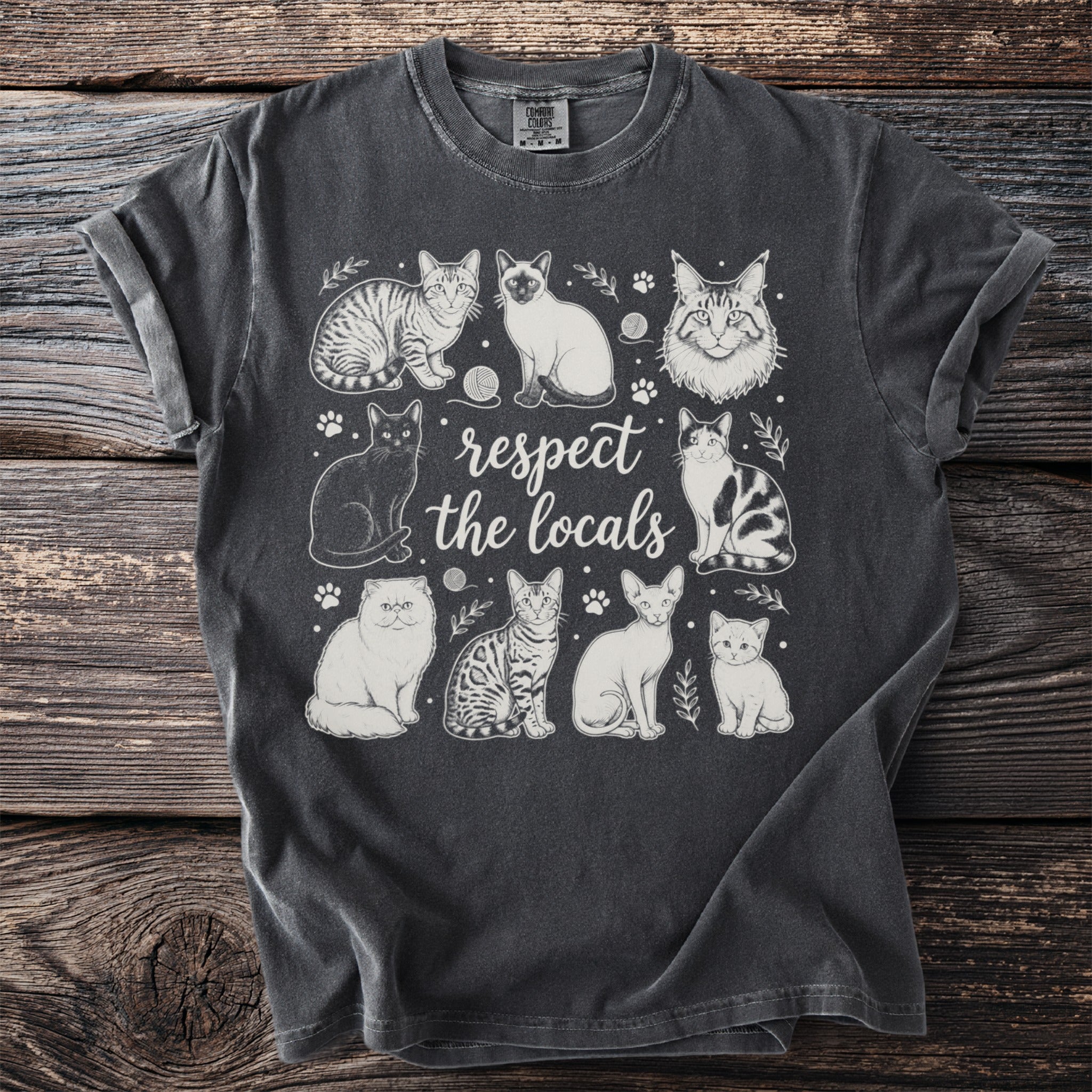 T-shirt featuring line drawings of various cats with the text "respect the locals."