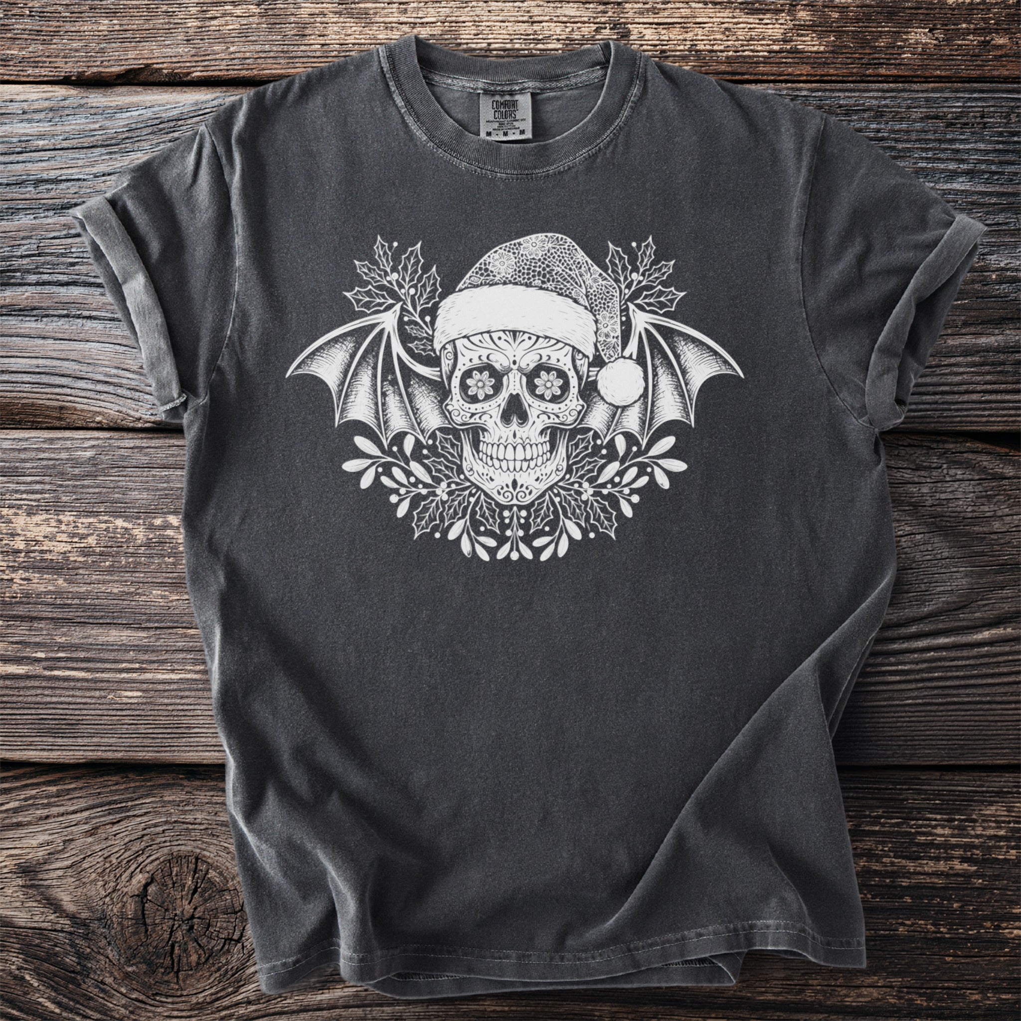 Dark gray t-shirt with white sugar skull, bat wings, Santa hat, and holly design.