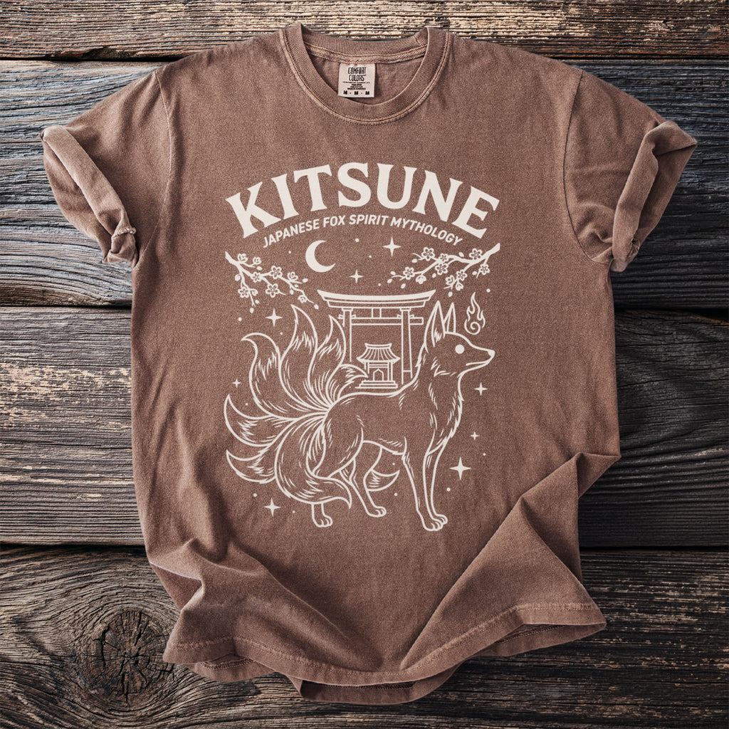 Brown t-shirt with white graphic of a nine-tailed fox, shrine, and text "Kitsune Japanese Fox Spirit Mythology".