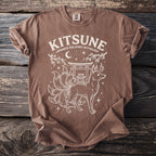 Brown t-shirt with white graphic of a nine-tailed fox, shrine, and text "Kitsune Japanese Fox Spirit Mythology".