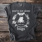 Dark grey t-shirt with "you're not alone there are bugs" and illustrated frog and insects.