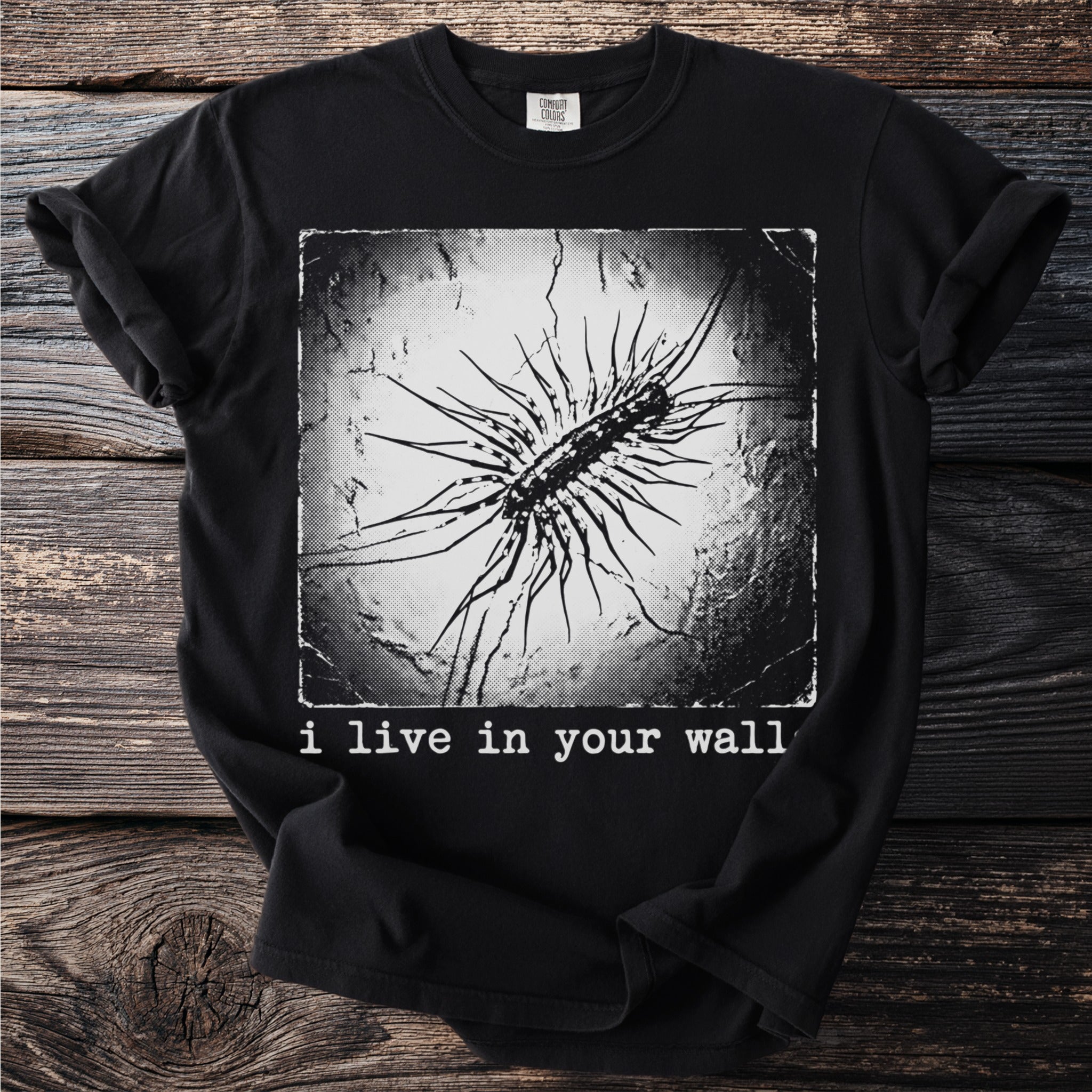 Black t-shirt with a centipede graphic and text: "i live in your wall".