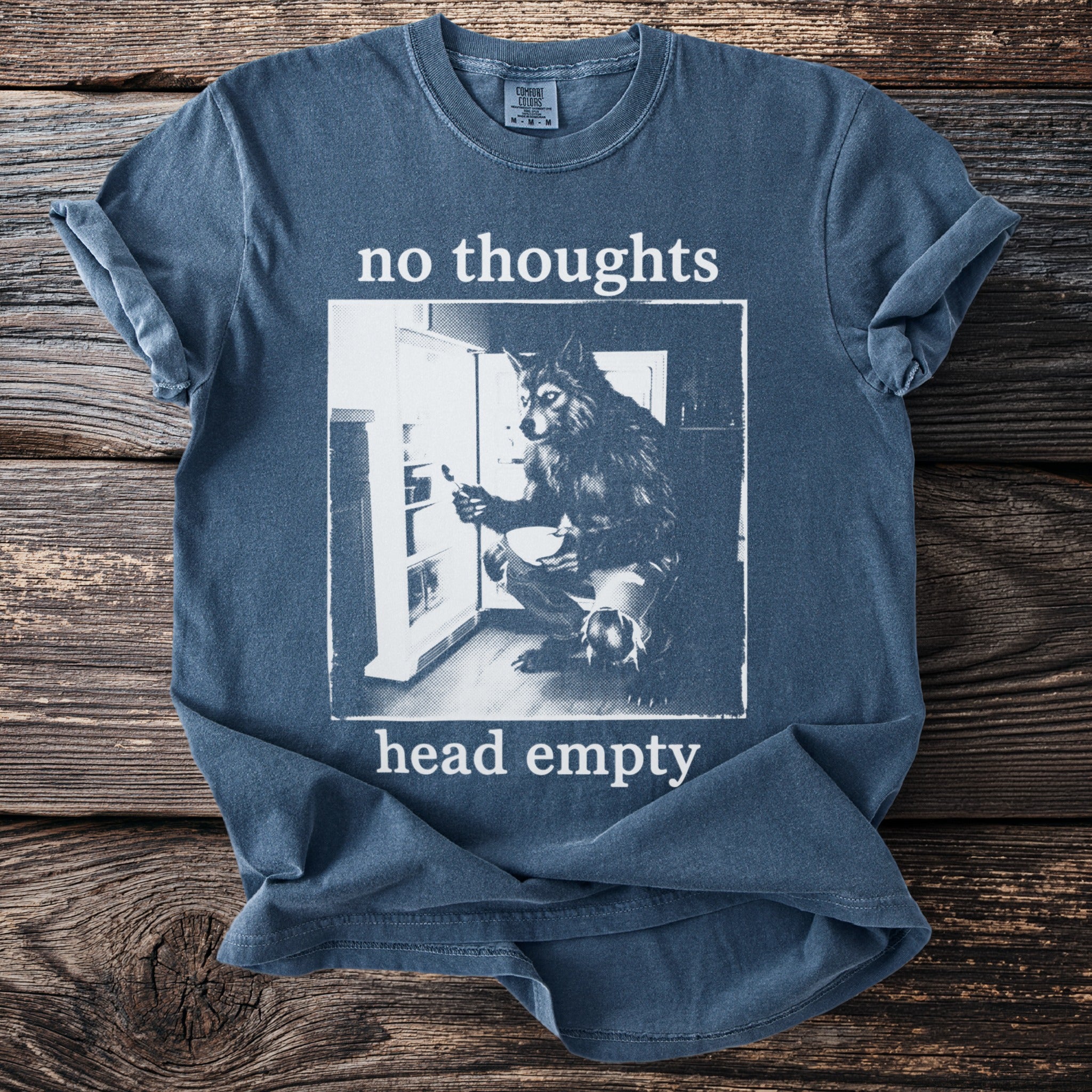 Blue t-shirt with "no thoughts head empty" text and wolf in refrigerator graphic.