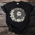 Black t-shirt with a circular Halloween design featuring bats, moon, pumpkin, and leaves.