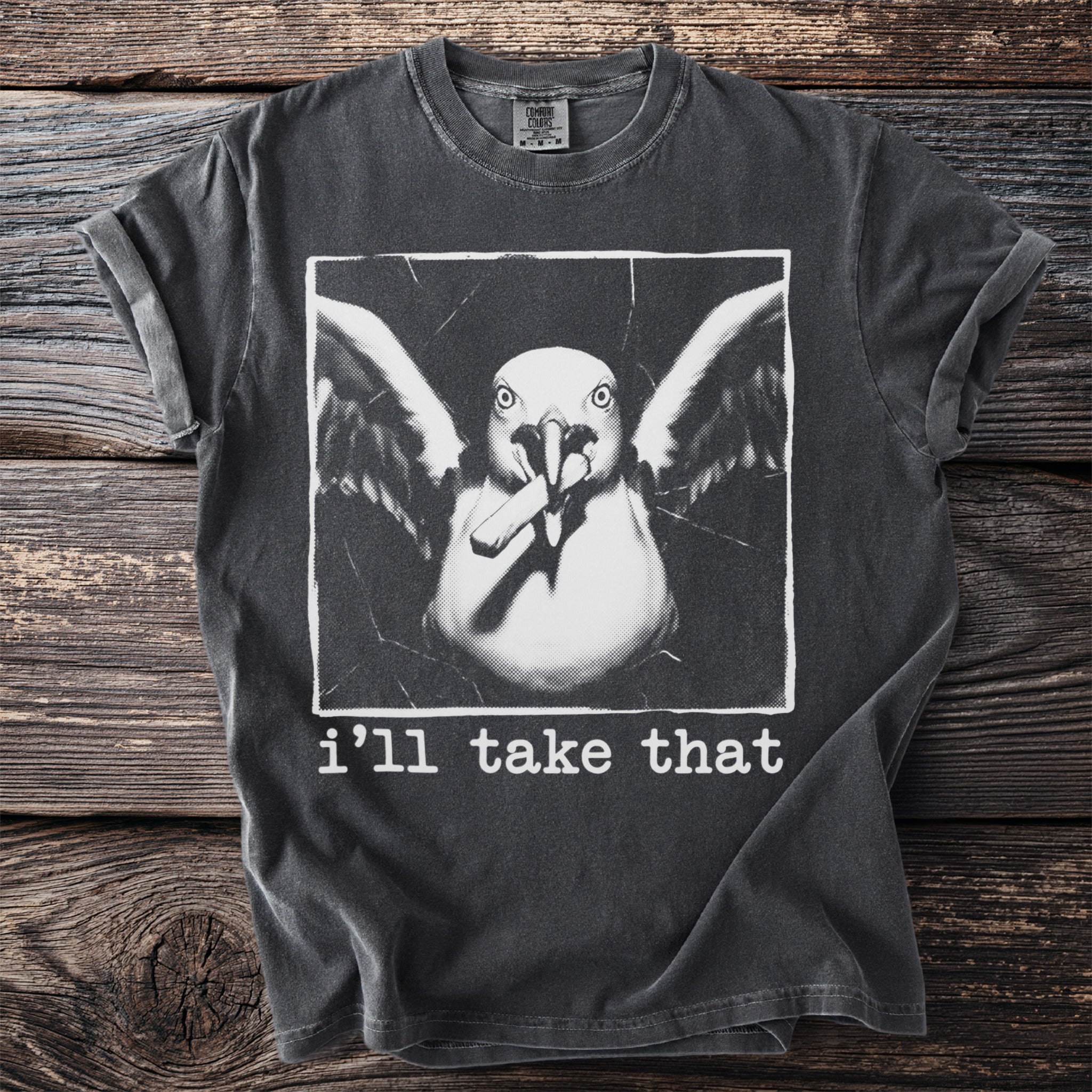 Dark grey t-shirt with a graphic of a seagull holding a cigarette and the text "i'll take that".