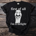 Black t-shirt with white text "first of all" above a goose and "i'm a delight" below.