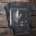 Charcoal t-shirt with a black and white image of a cat peeking from behind fabric and text "please do not perceive me".