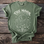 Green t-shirt with white graphic of moon, wolves, towers, and lobster.