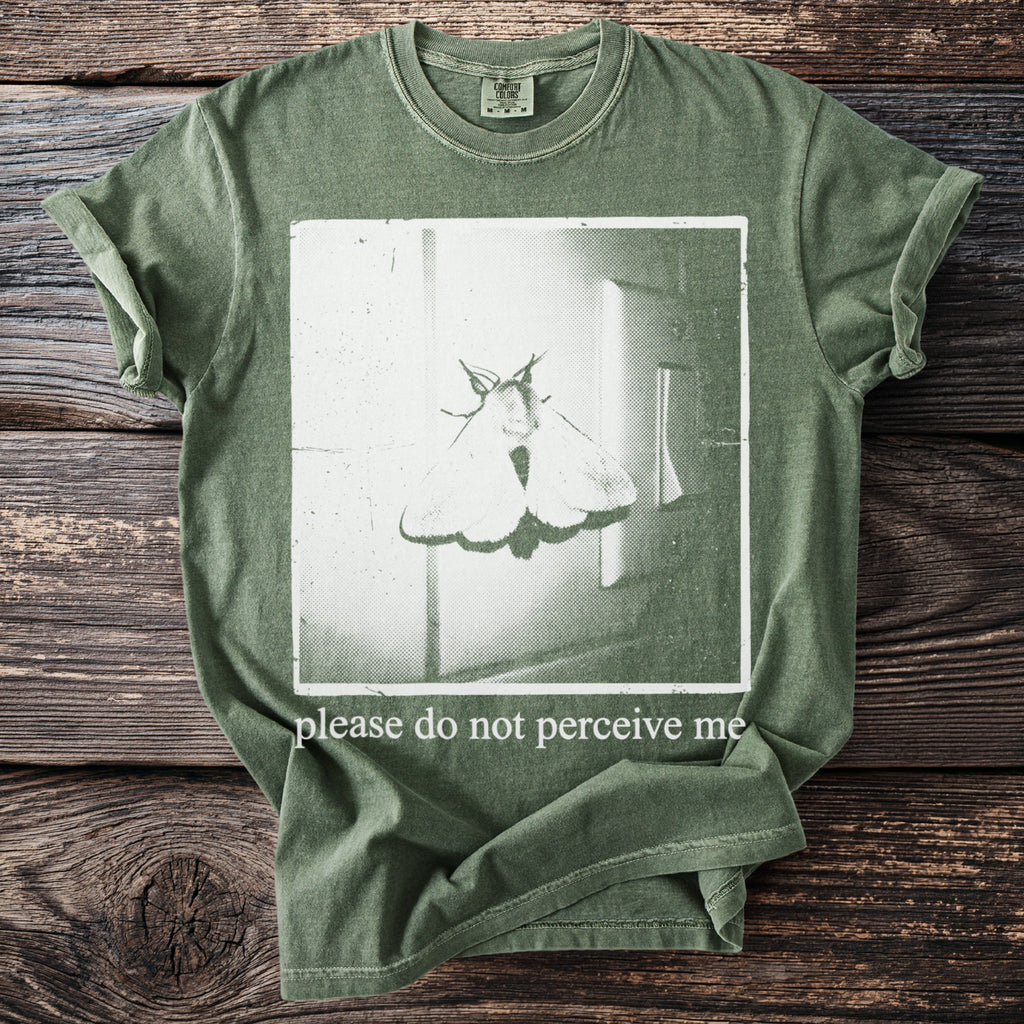 Green t-shirt with moth graphic and text "please do not perceive me".