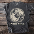 Pepper t-shirt with "WILDER NORTH" above a musk ox and stoat in a grass wreath.