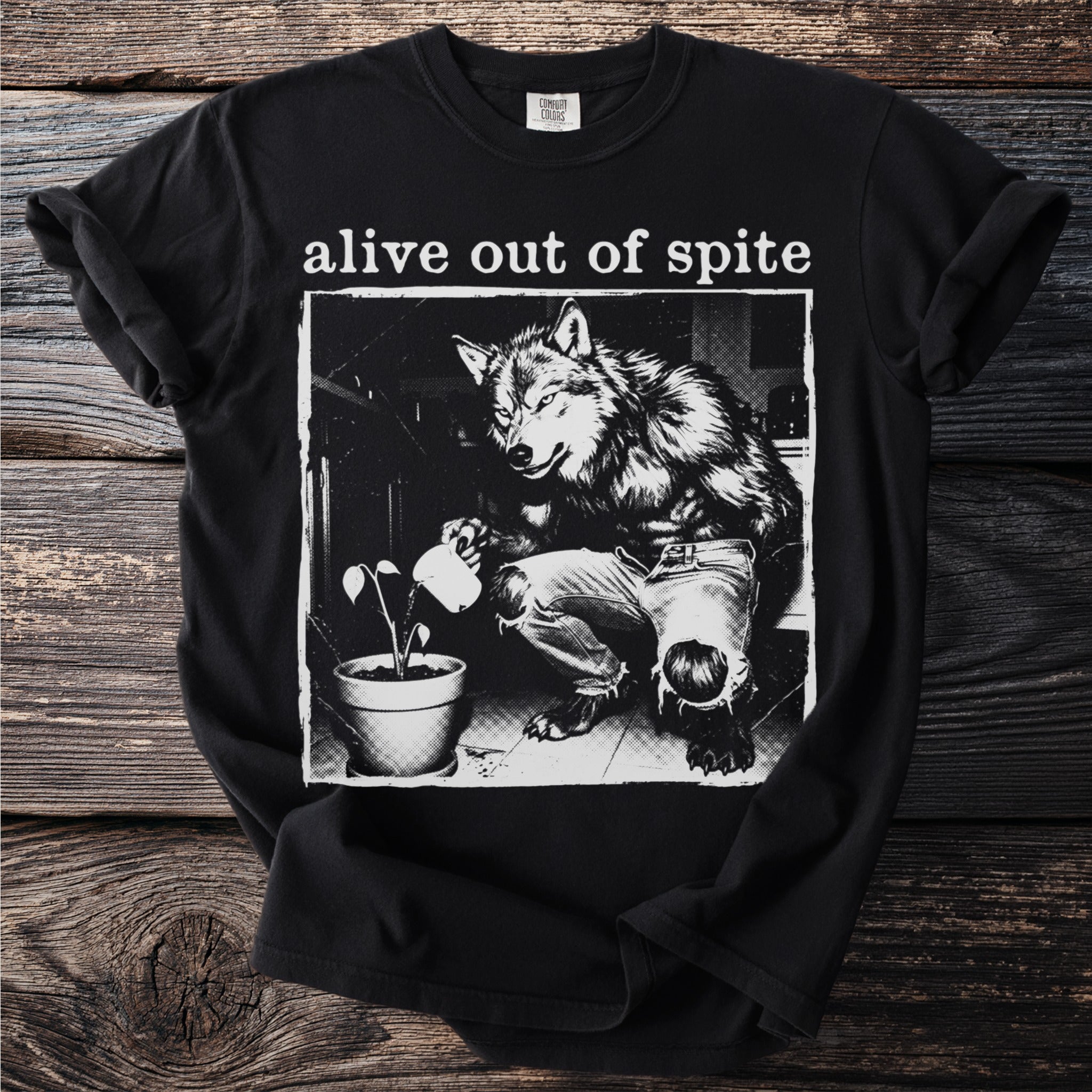 Black t-shirt with werewolf watering a plant, text "alive out of spite"