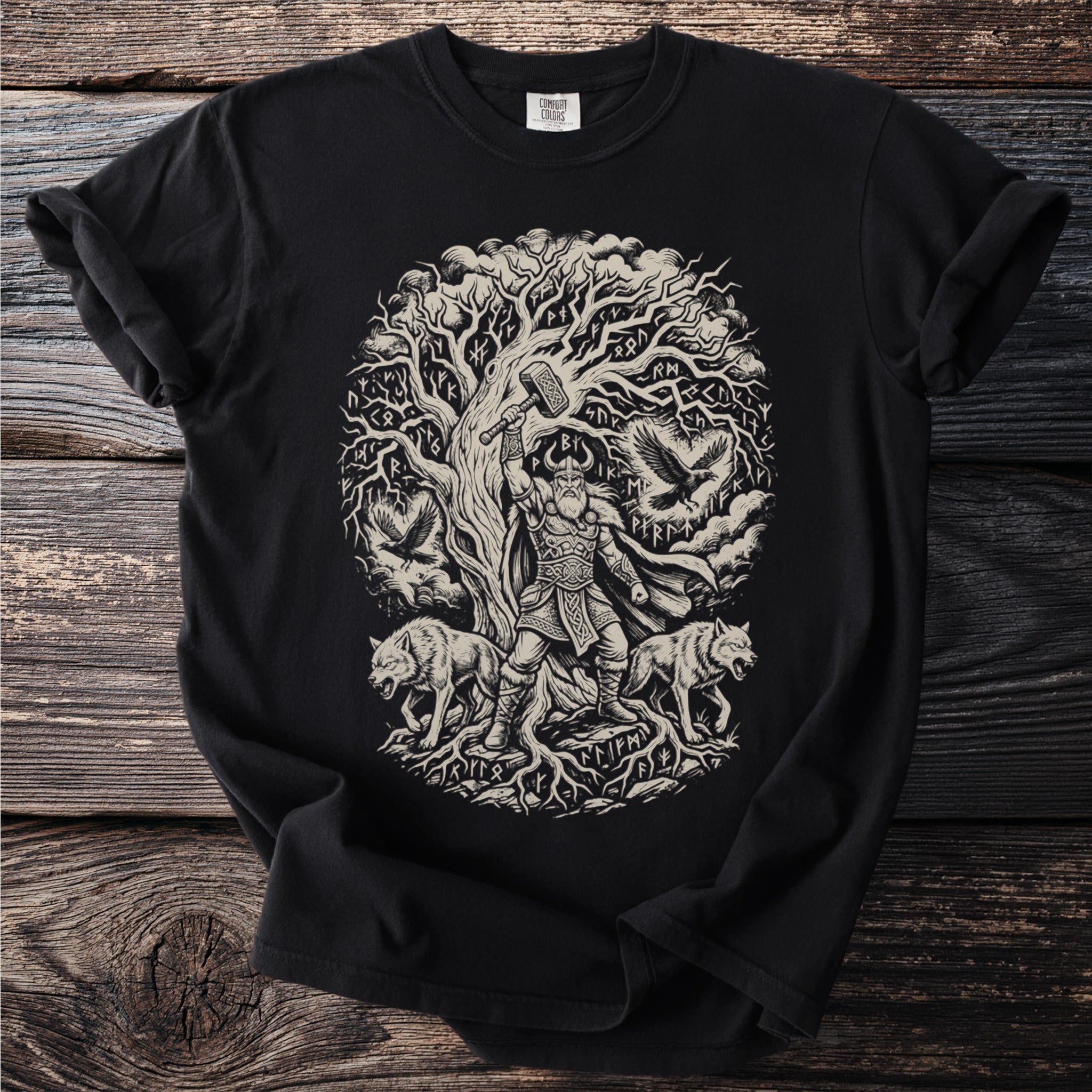 Black t-shirt graphic featuring Thor holding Mjolnir under a rune-covered tree with wolves and ravens.