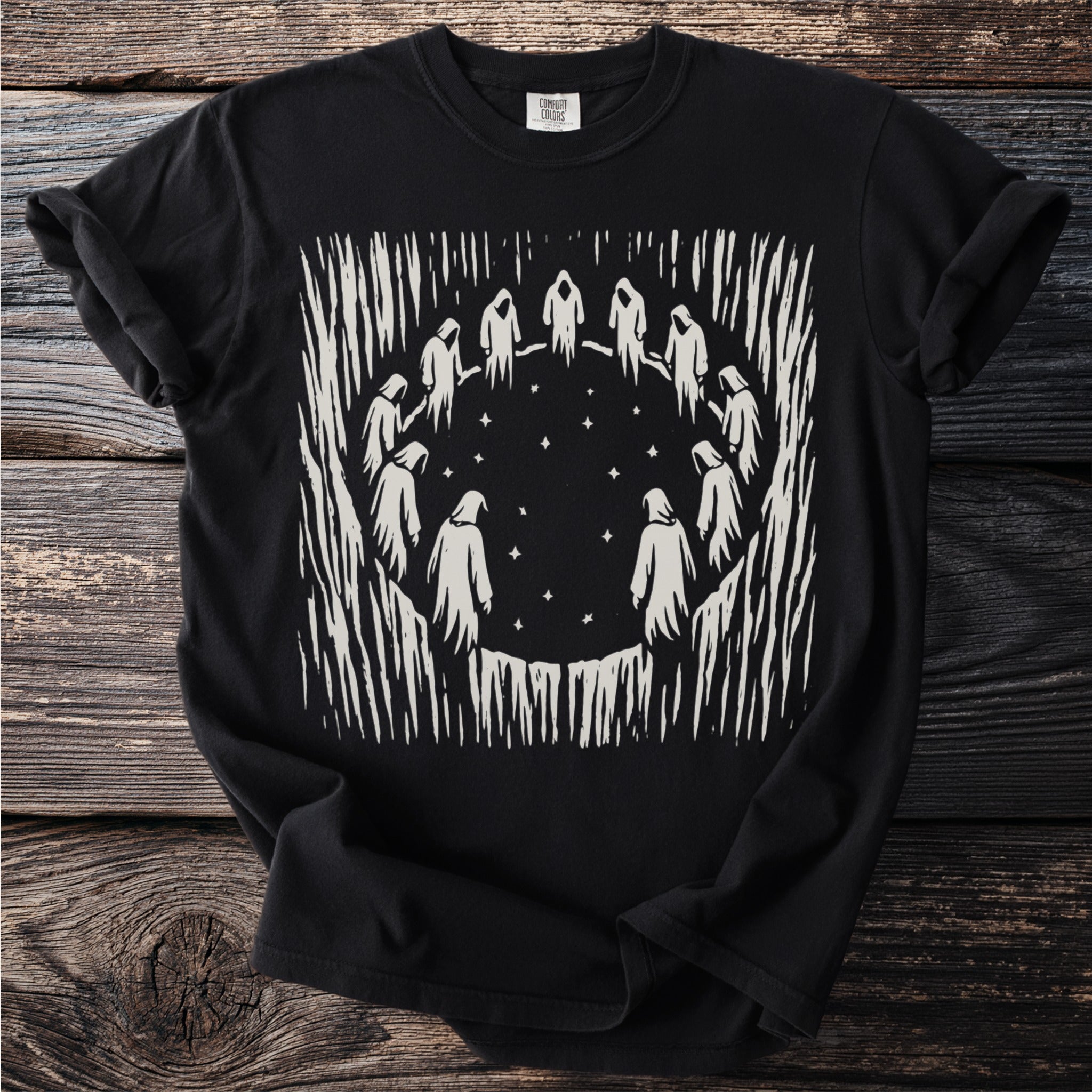 Black t-shirt with a cream-colored graphic of hooded figures in a circle under stars.