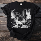 Black t-shirt with a cat on a bed surrounded by bugs and text saying "you're not alone there are bugs."