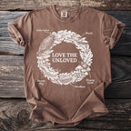 Brown t-shirt with "Love the Unloved" text surrounded by insects and animals.