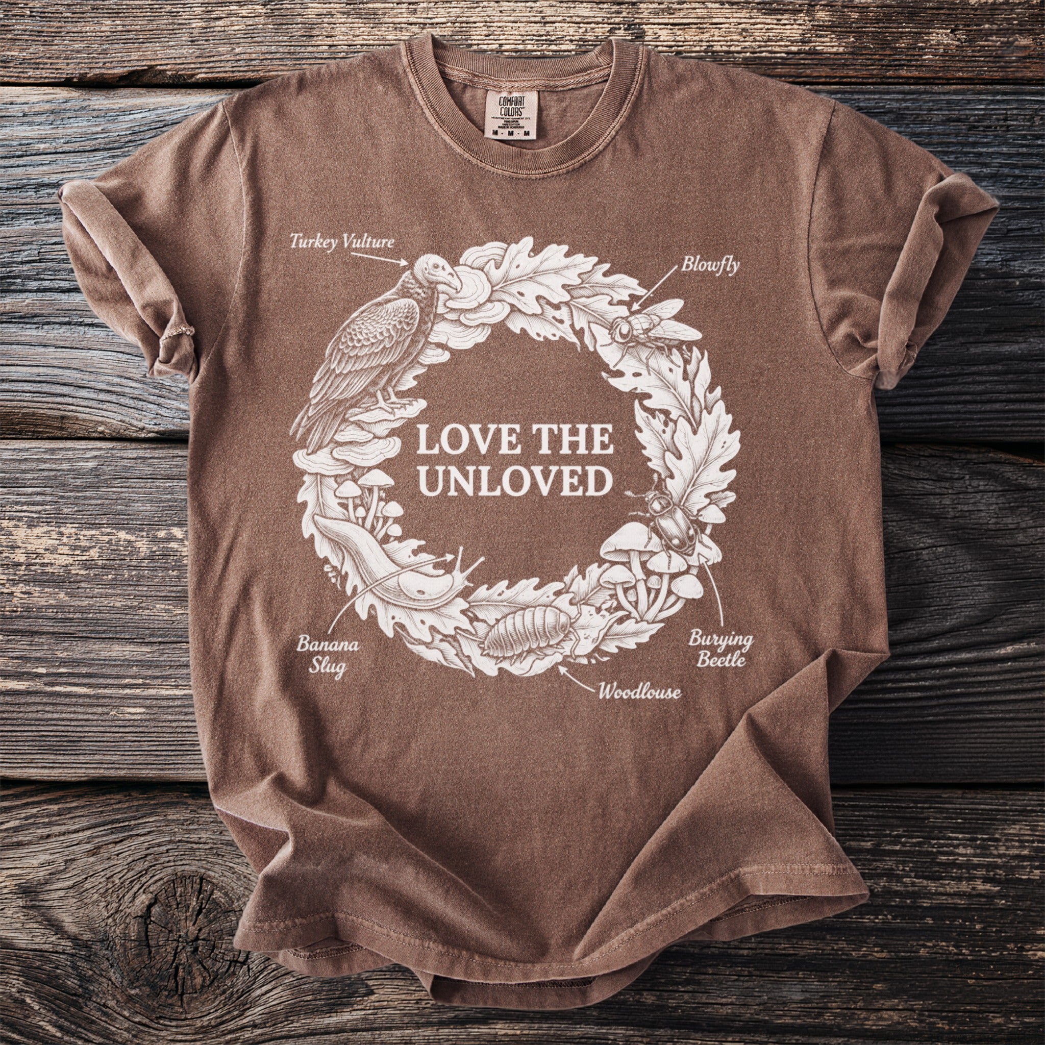 Brown t-shirt with "Love the Unloved" text surrounded by insects and animals.