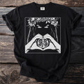 Black t-shirt with a white graphic of a woman's eyes and hands holding a pomegranate.