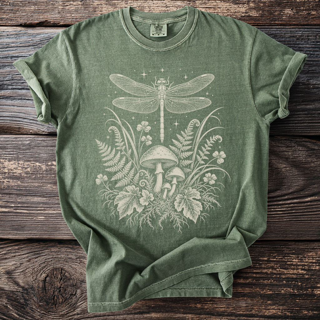 Green t-shirt with white dragonfly, mushrooms, ferns, and clover graphic.