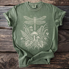 Green t-shirt with white dragonfly, mushrooms, ferns, and clover graphic.