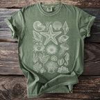Green t-shirt with a white line drawing of various sea creatures and shells.