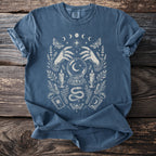 Blue t-shirt with occult design featuring hands, crystal ball, moon phases, and moths.