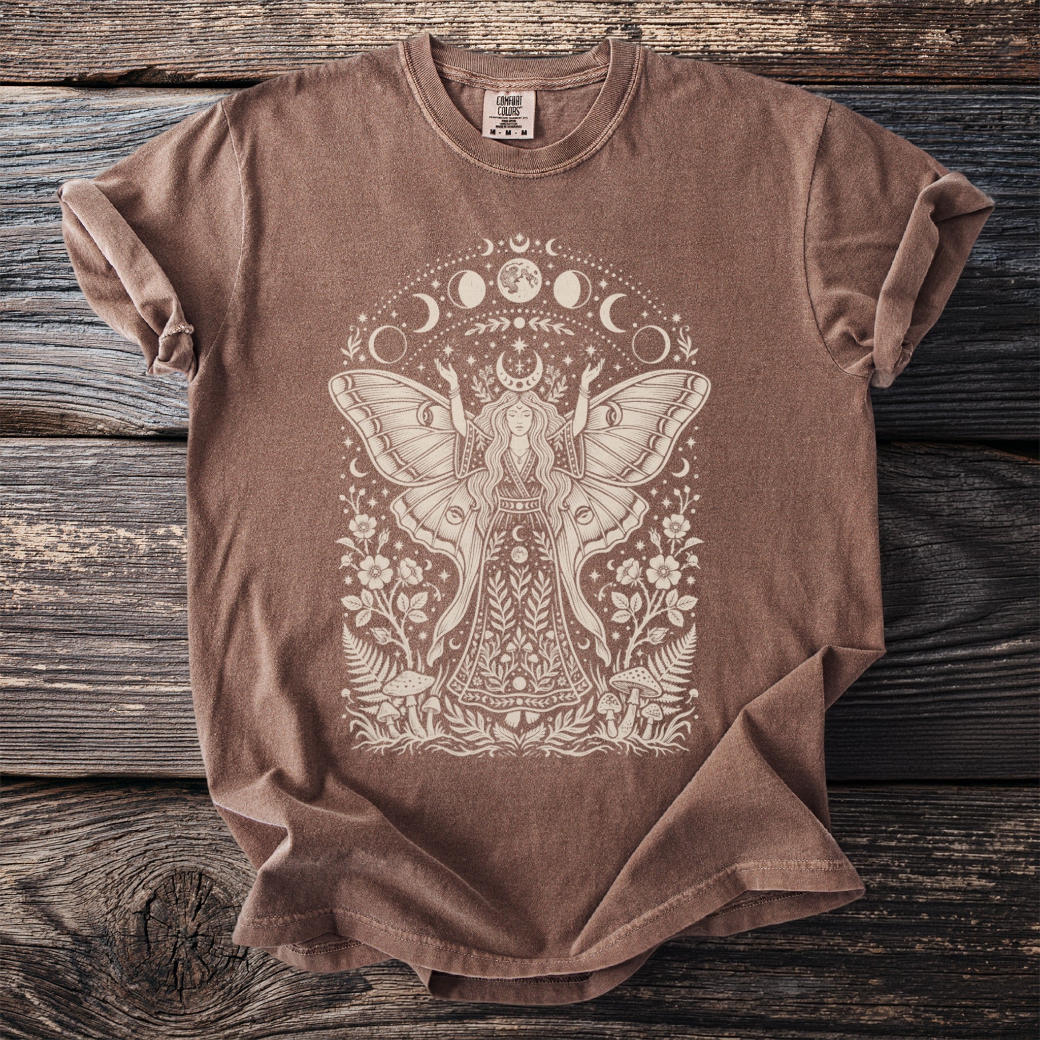 Brown t-shirt with white moth fairy, moon phases, and floral design.