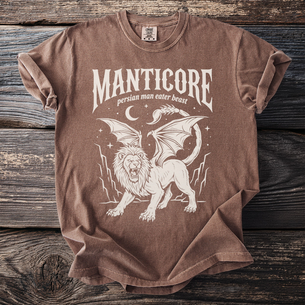 Manticore graphic tee with text "MANTICORE: persian man eater beast" on brown shirt.