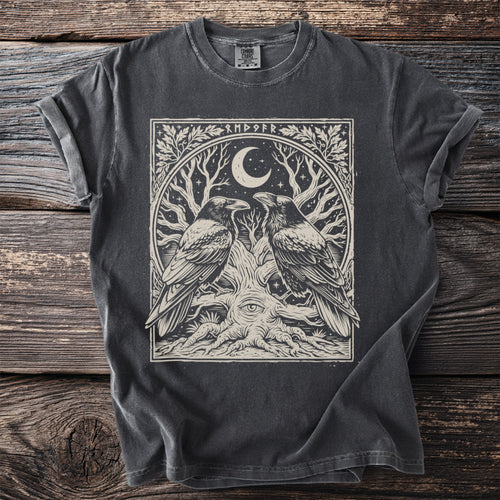 Dark grey t-shirt with a circular graphic of two ravens, a crescent moon, star, and an eye within a tree.