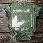 Green t-shirt with white text "girls will be girls" and graphic.