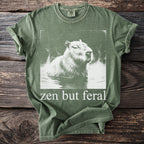 Green t-shirt with white capybara graphic and text "zen but feral".