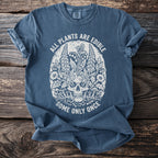 Blue t-shirt with skull and plant graphic: "ALL PLANTS ARE EDIBLE SOME ONLY ONCE"