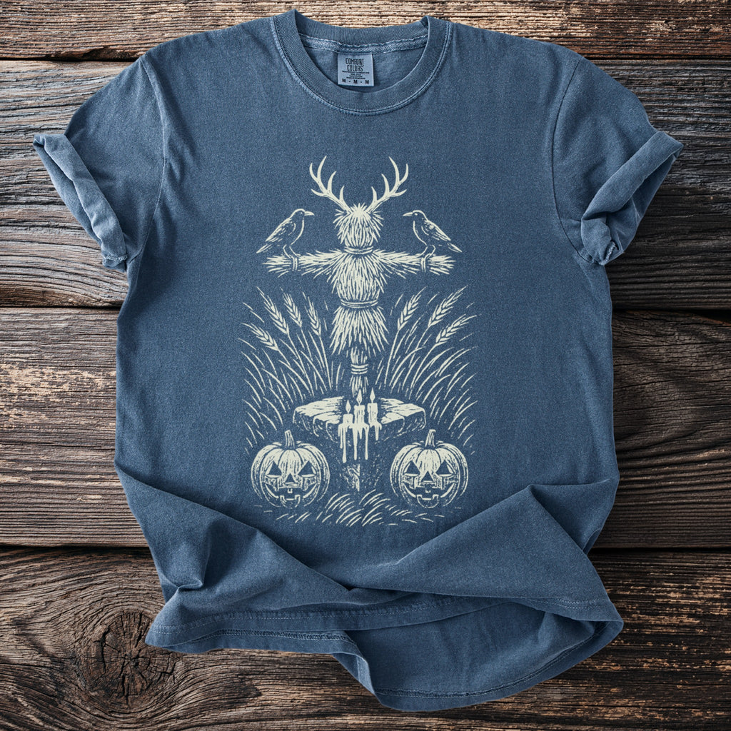 T-shirt with scarecrow, crows, pumpkins, candles, and wheat graphic.