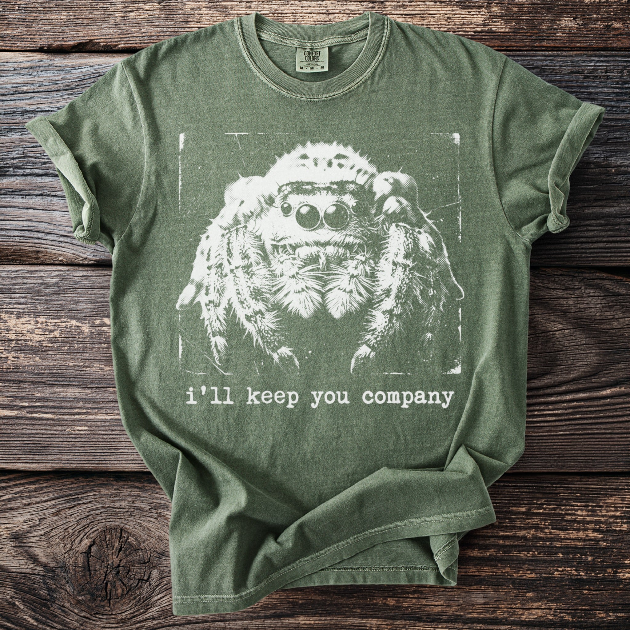 Green t-shirt with white jumping spider graphic and text "i'll keep you company."