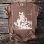 Brown t-shirt with white graphic of a cat drinking an iced beverage, wearing sunglasses.