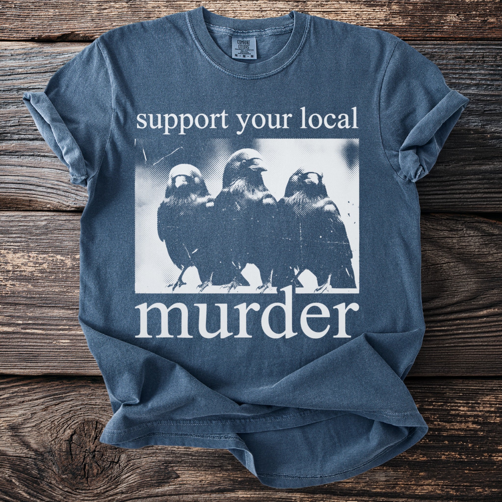 A blue t-shirt with the text "support your local murder" and three crows.