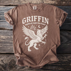 Brown t-shirt with white graphic of a griffin, castle, moon, and stars.