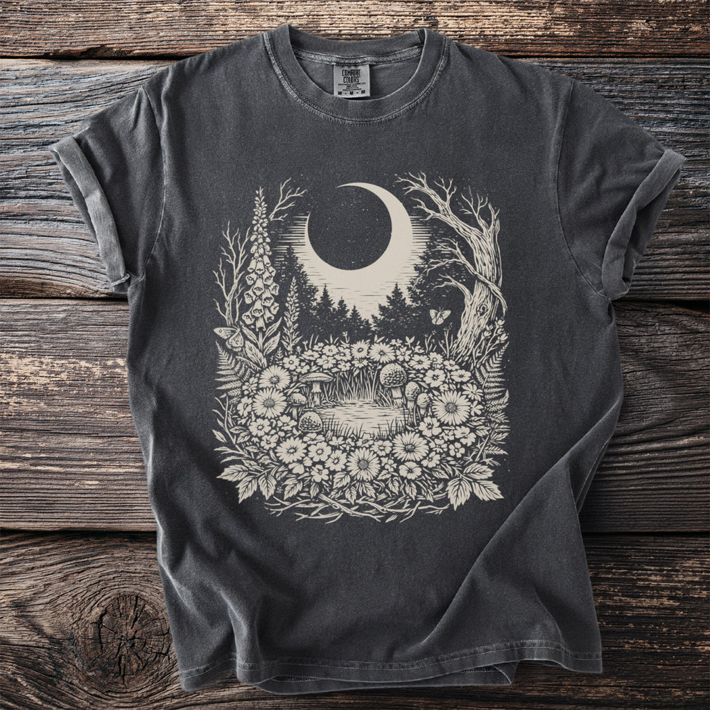 Dark t-shirt with a whimsical forest, moon, and mushroom design.