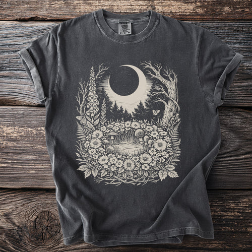Dark t-shirt with a whimsical forest, moon, and mushroom design.