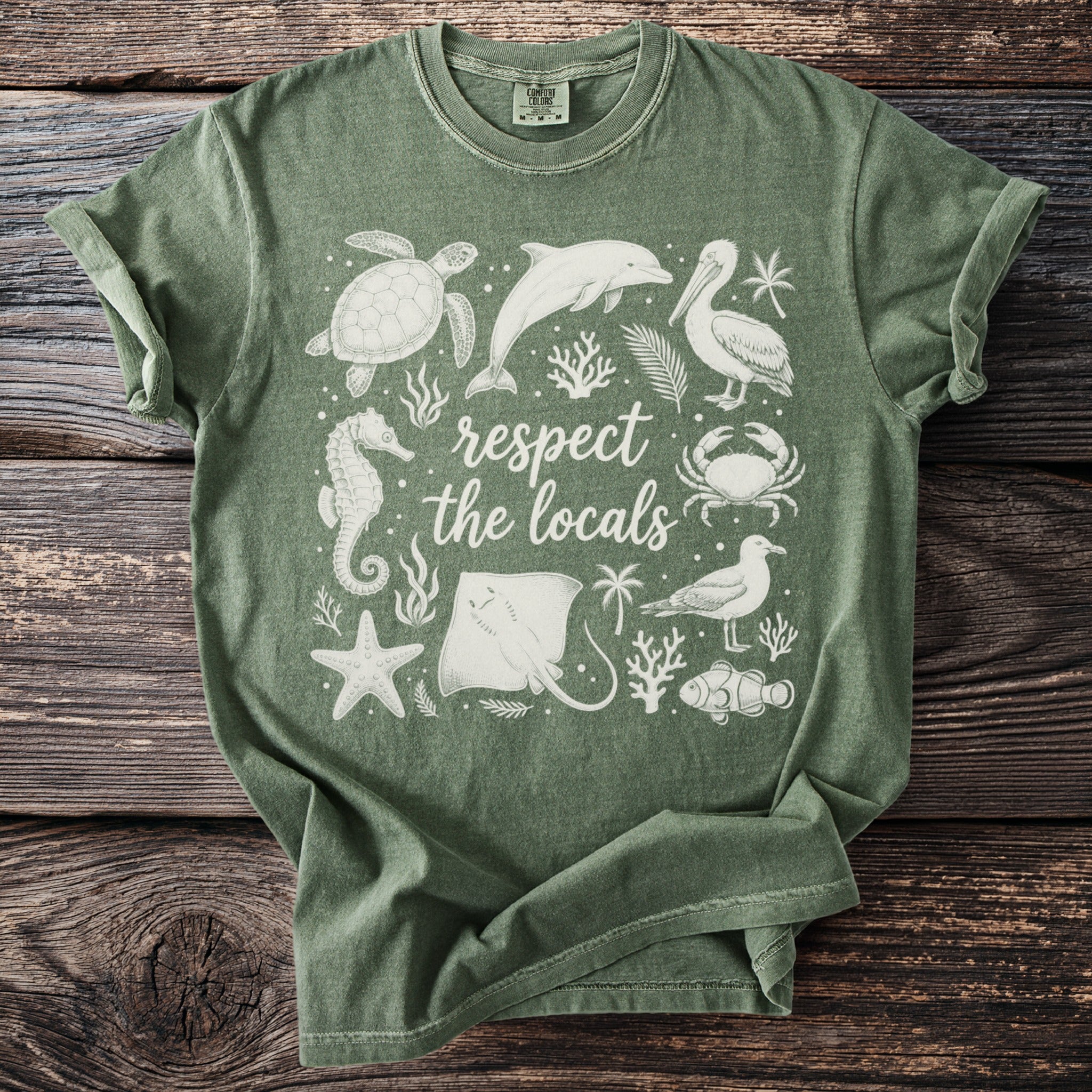 Green t-shirt with white graphic of marine animals and "respect the locals" text.