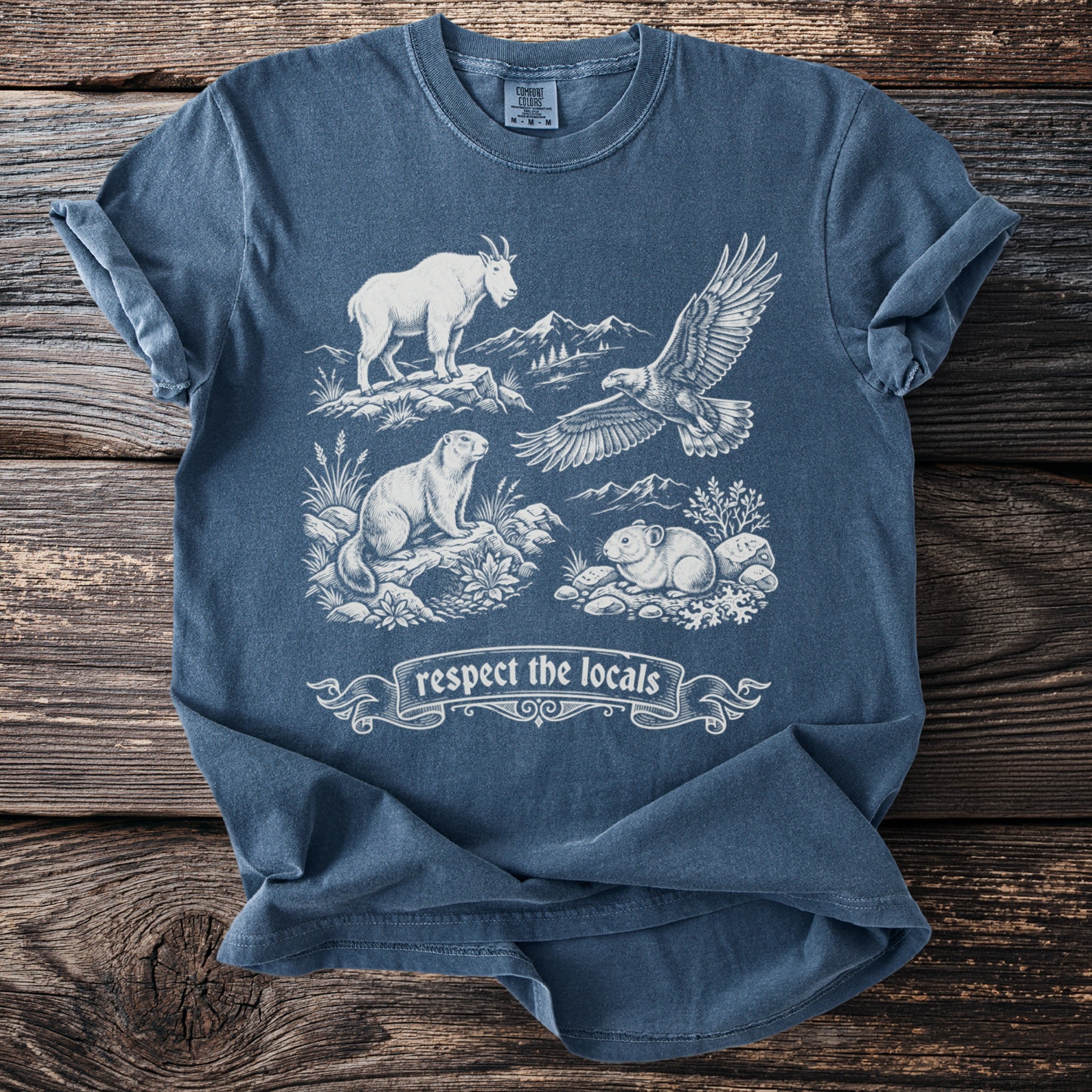 Comfort Colors t-shirt featuring a mountain goat, eagle, marmot, and pika with "respect the locals" banner.