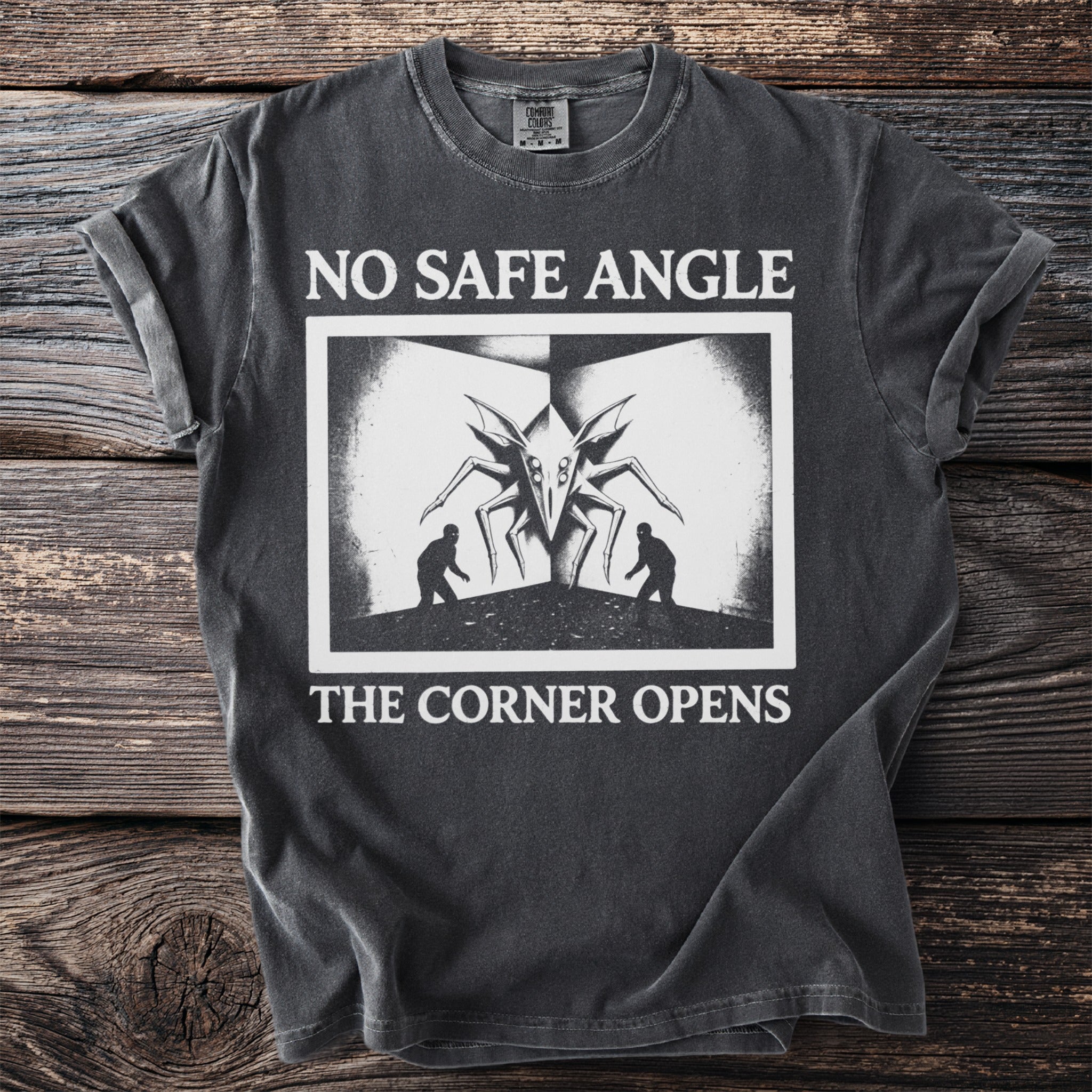 T-shirt with "NO SAFE ANGLE THE CORNER OPENS" text and a creature with two figures.
