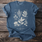 Blue t-shirt with botanical illustrations of tea ingredients and the text "The Tea Garden".