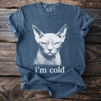 Blue t-shirt with a white print of a grumpy Sphynx cat and the text "i'm cold".