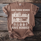 T-shirt with graphic reading "God forbid women have hobbies" and mystical illustrations.