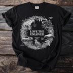 Black t-shirt with "Love the Unloved" text and illustrations of unusual animals.