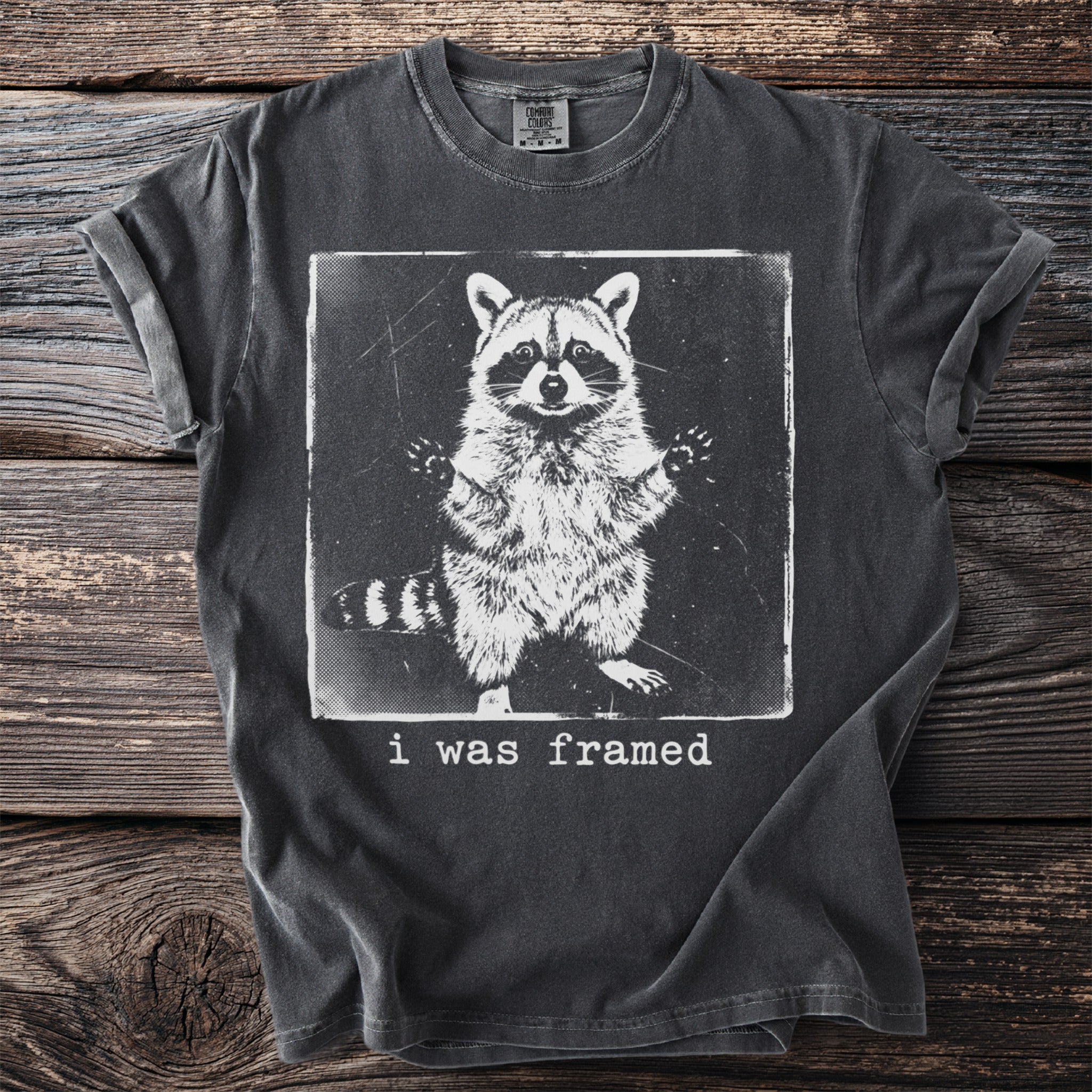 Gray t-shirt with a black and white graphic of a raccoon with text "i was framed."