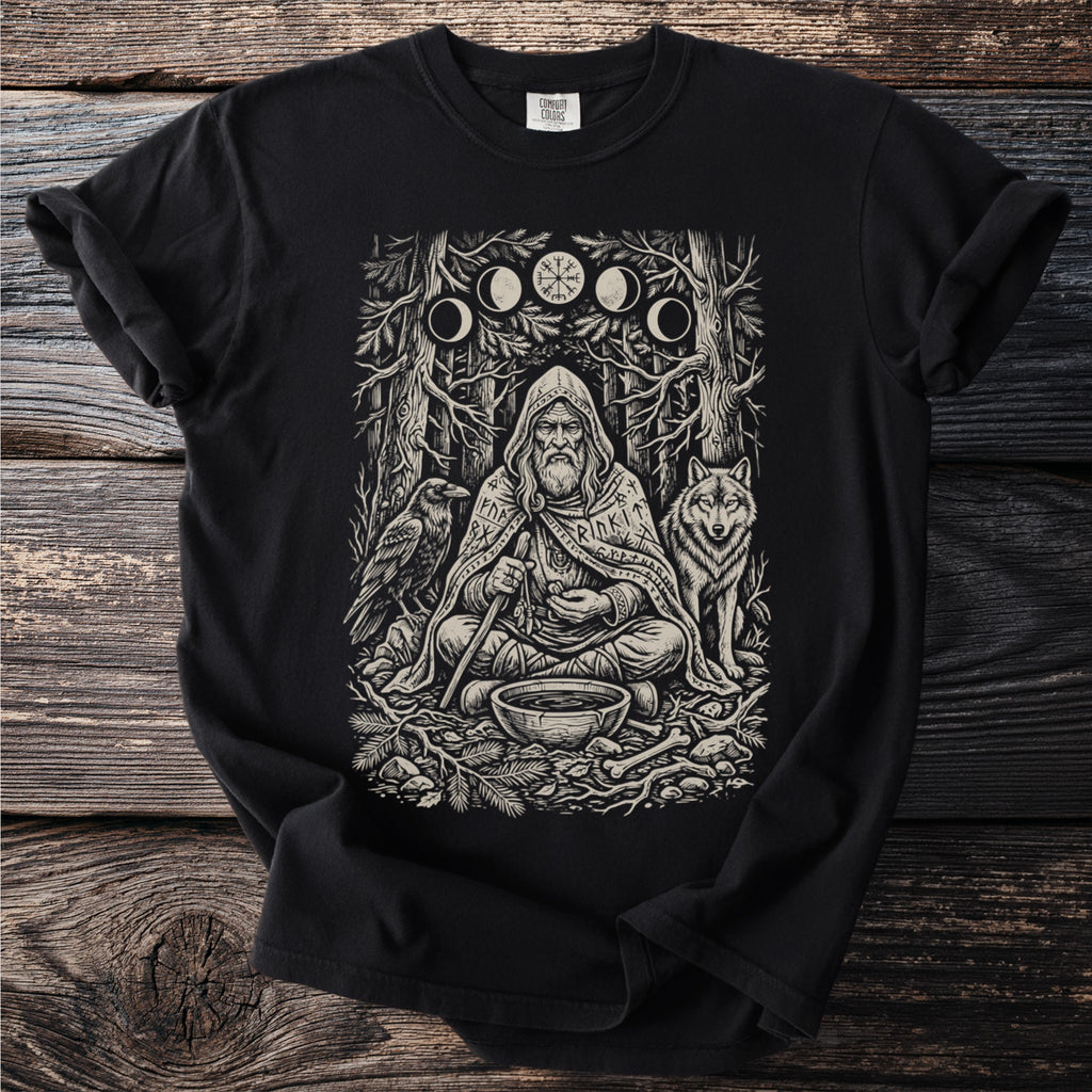 T-shirt graphic of a bearded man with a wolf and raven in a forest scene.