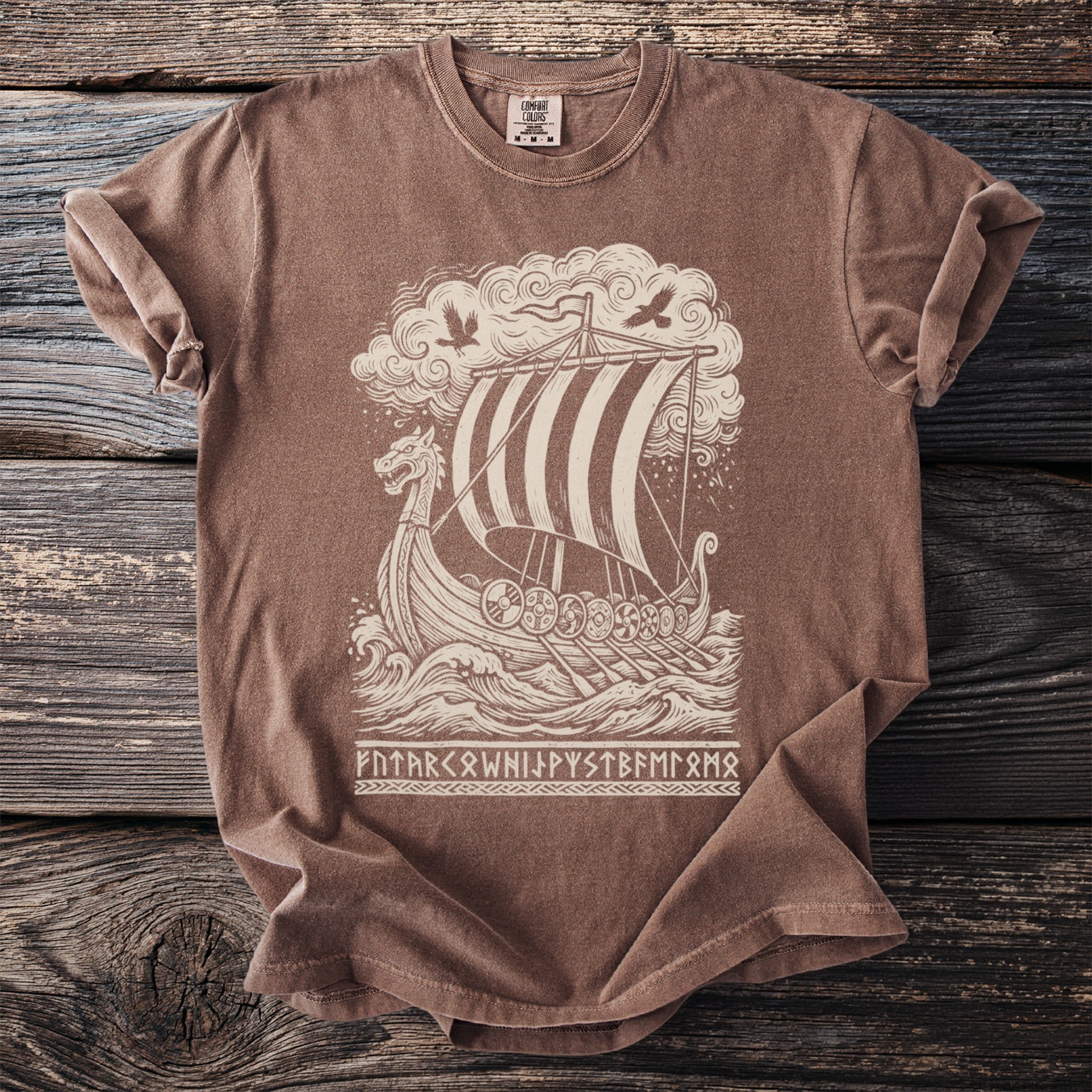 Brown t-shirt with a cream-colored viking ship illustration and runic text.
